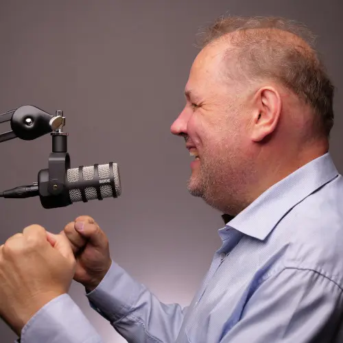 Mies puhuu mikrofoniin